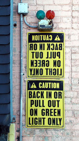 A caution sign with instruction written in mirror writing and in regular writing